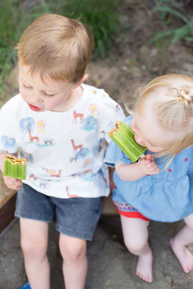 boy and girl toddlers eating healthy green smoothie popsicles